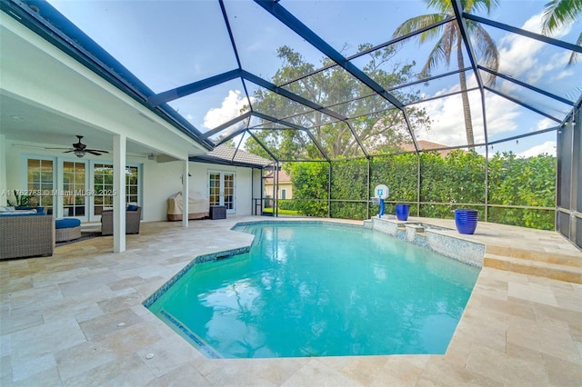 view of swimming pool featuring french doors, ceiling fan, glass enclosure, and a patio area