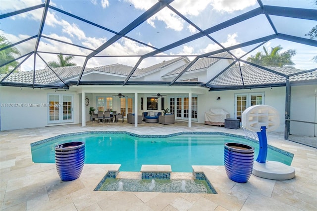 view of swimming pool featuring a pool with connected hot tub, french doors, outdoor lounge area, a ceiling fan, and a patio