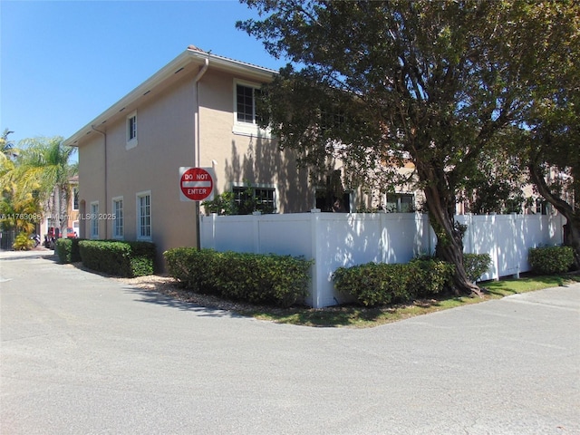 view of property exterior with a fenced front yard and stucco siding