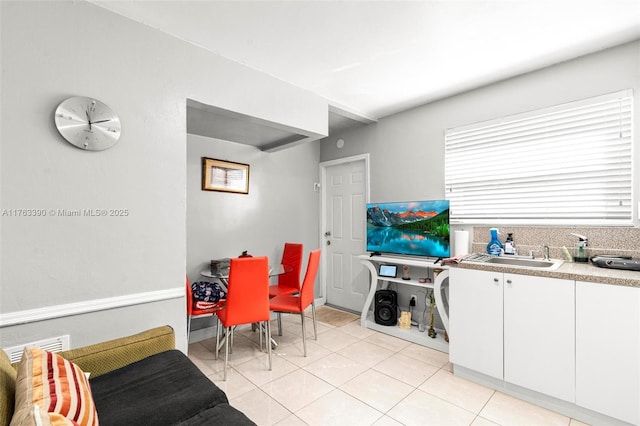 interior space featuring a sink, white cabinets, light countertops, and light tile patterned floors