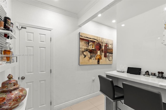 office area featuring crown molding, light tile patterned flooring, baseboards, and built in desk