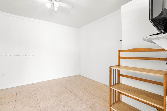 spare room featuring tile patterned floors, baseboards, a ceiling fan, and ornamental molding