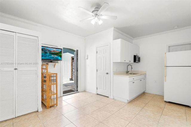 kitchen featuring a ceiling fan, a sink, freestanding refrigerator, black microwave, and light countertops