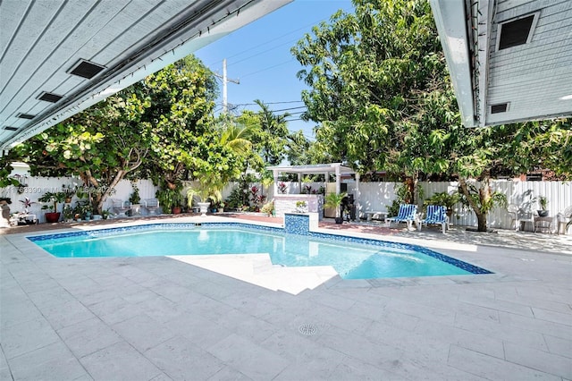 view of swimming pool with a fenced in pool, a fenced backyard, and a patio area