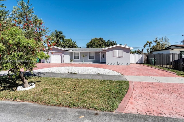 single story home featuring a front lawn, an attached garage, driveway, and fence