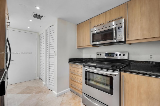 kitchen featuring visible vents, baseboards, recessed lighting, dark stone countertops, and stainless steel appliances