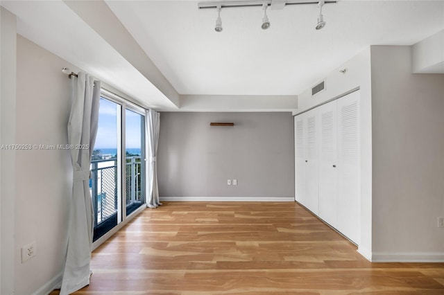 unfurnished bedroom with visible vents, access to outside, a closet, light wood finished floors, and baseboards