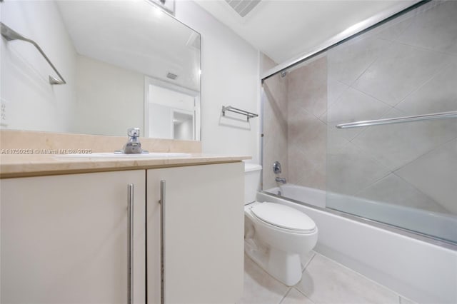 full bathroom with visible vents, toilet, tile patterned floors, combined bath / shower with glass door, and vanity