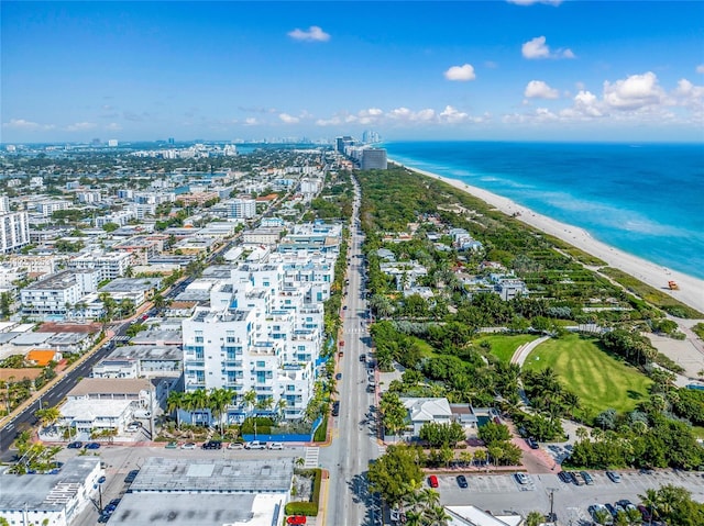 drone / aerial view with a city view, a view of the beach, and a water view