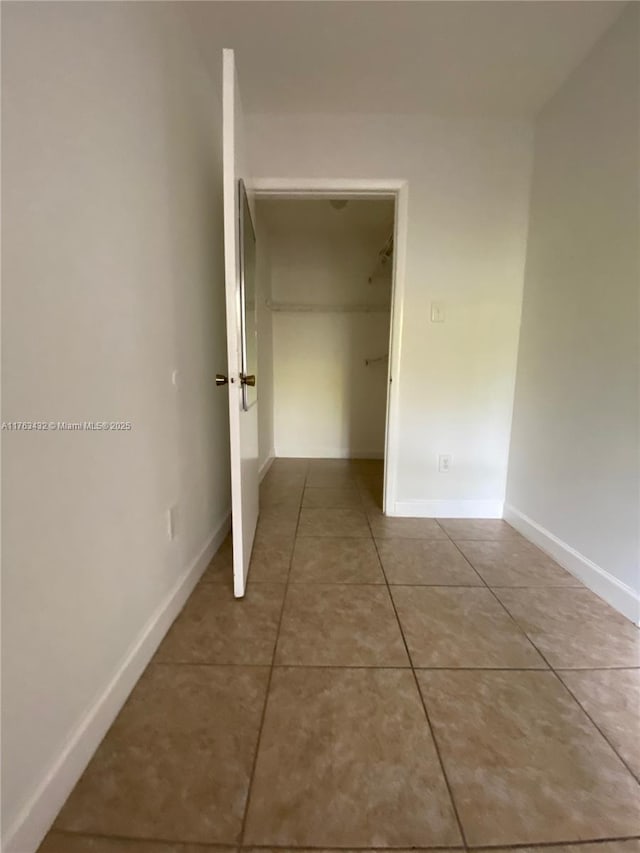 hall with tile patterned floors and baseboards