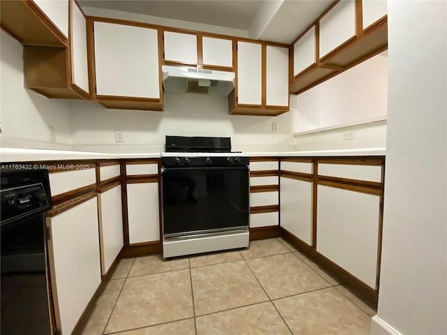 kitchen with under cabinet range hood, range with gas stovetop, light tile patterned flooring, and light countertops