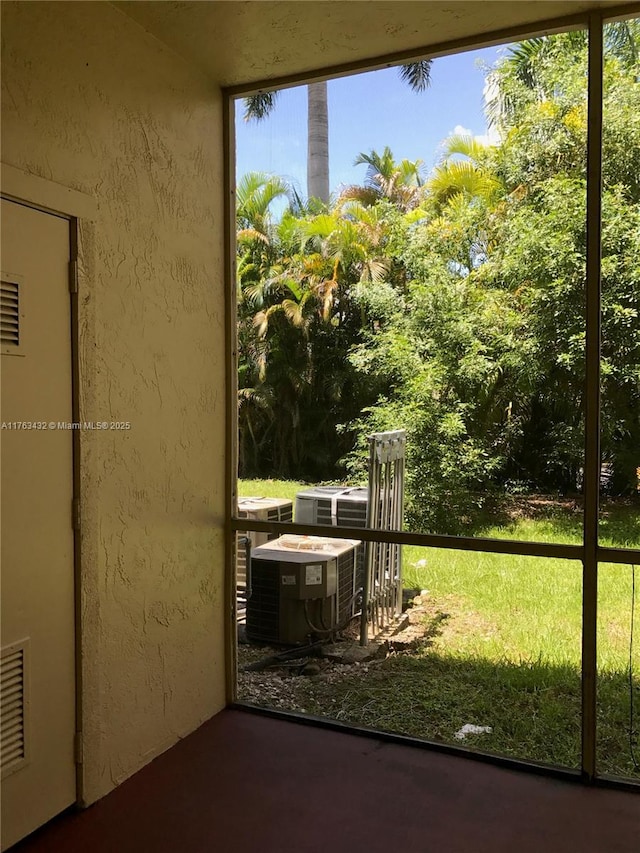 doorway to outside featuring a textured wall and visible vents