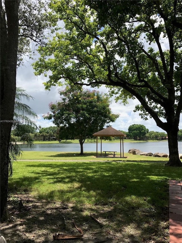 view of community with a gazebo, a water view, and a lawn