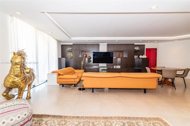 tiled living room featuring a raised ceiling and recessed lighting