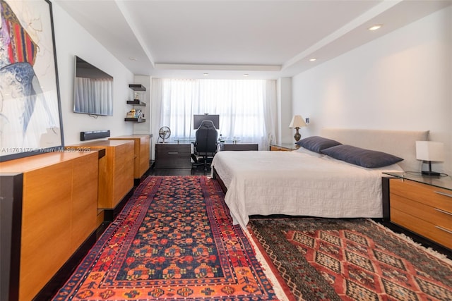 bedroom with a raised ceiling and recessed lighting