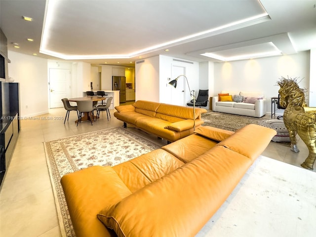 living room with recessed lighting and a raised ceiling