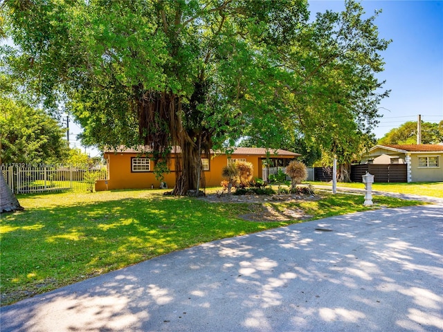 view of front of home with a front yard and fence