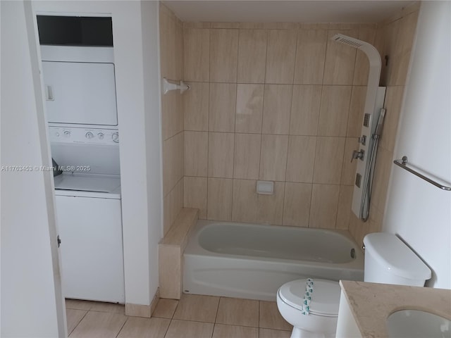 full bath with vanity,  shower combination, tile patterned flooring, stacked washer / dryer, and toilet