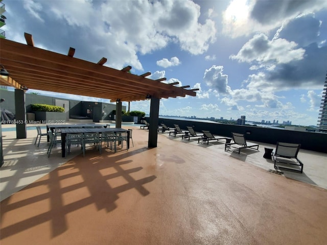 view of patio with a view of city, a community pool, and a pergola