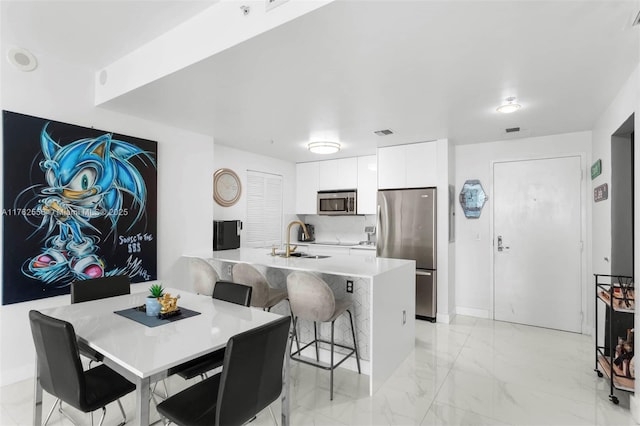 dining space featuring visible vents, baseboards, and marble finish floor