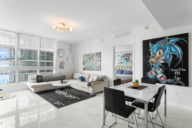 living area with visible vents, baseboards, a notable chandelier, and marble finish floor