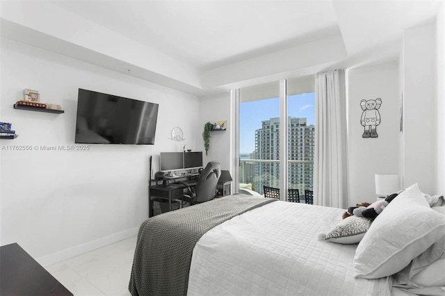 bedroom featuring baseboards, marble finish floor, and access to outside