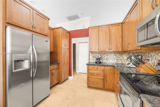 kitchen with dark stone countertops, decorative backsplash, appliances with stainless steel finishes, and ornamental molding