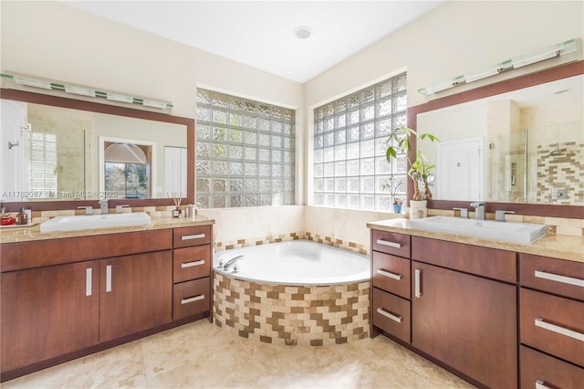 bathroom featuring a shower stall, two vanities, and a sink