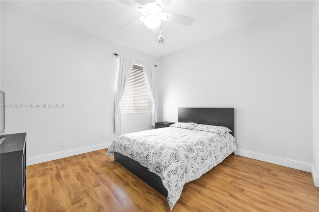 bedroom featuring baseboards, light wood finished floors, and ceiling fan