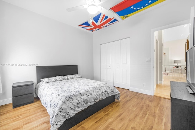 bedroom featuring a closet, a ceiling fan, light wood-type flooring, and baseboards