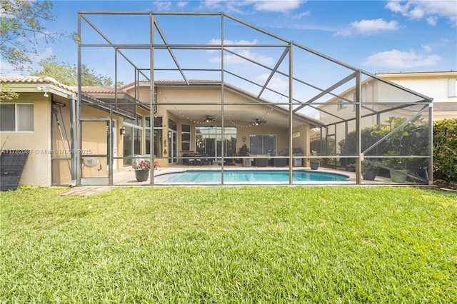 back of property featuring stucco siding, a lawn, ceiling fan, a patio, and a lanai