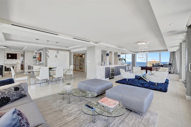 living area with beverage cooler, light tile patterned floors, a raised ceiling, and a notable chandelier