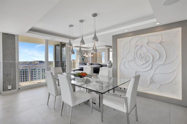 dining area featuring expansive windows, a raised ceiling, plenty of natural light, and a chandelier