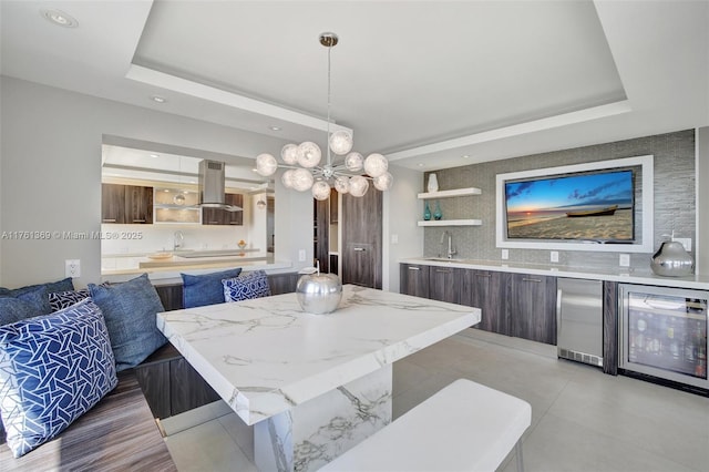 dining area featuring recessed lighting, a raised ceiling, and beverage cooler