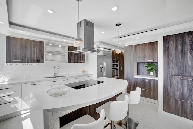 kitchen featuring island exhaust hood, modern cabinets, appliances with stainless steel finishes, and a sink