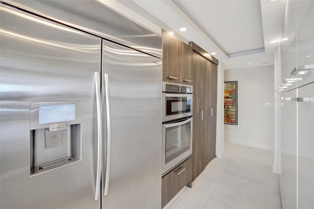 kitchen with light tile patterned floors, brown cabinetry, recessed lighting, stainless steel appliances, and modern cabinets