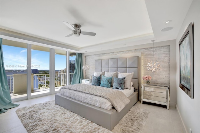 bedroom with access to outside, expansive windows, a tray ceiling, recessed lighting, and baseboards