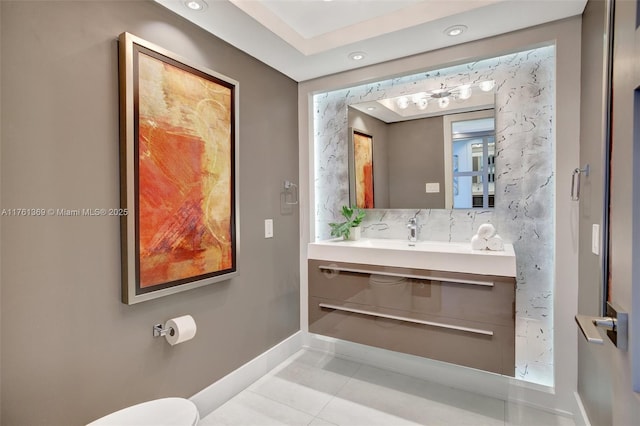 bathroom featuring baseboards, toilet, decorative backsplash, tile patterned floors, and vanity