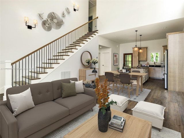 living room with visible vents, stairway, a high ceiling, and dark wood-style flooring