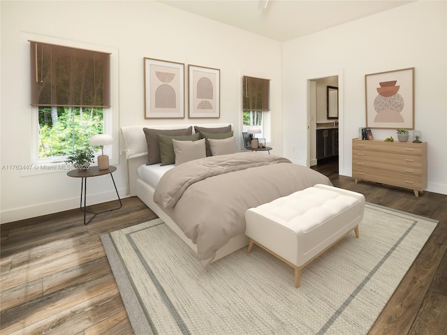 bedroom with wood finished floors, baseboards, and connected bathroom