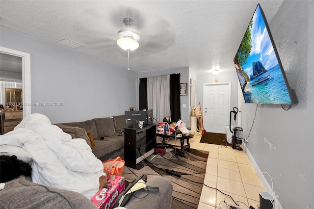 living room featuring tile patterned floors, baseboards, visible vents, and a textured ceiling