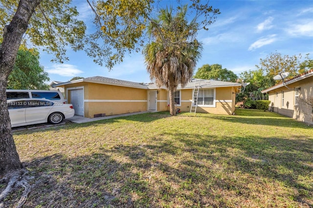 view of front of house with stucco siding, a front yard, and a garage