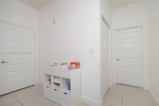 rec room with light tile patterned floors and baseboards