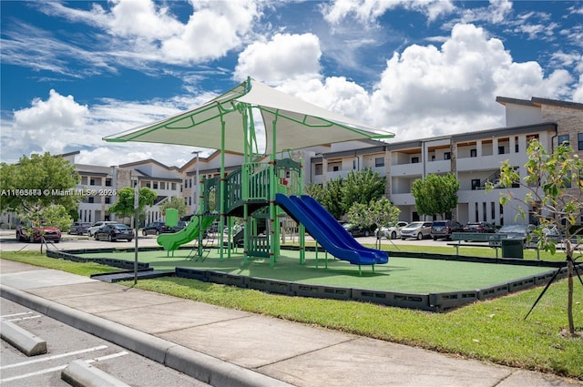 community jungle gym with a lawn and a residential view