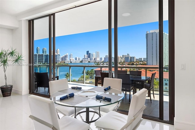 dining room featuring tile patterned floors, baseboards, a view of city, and floor to ceiling windows