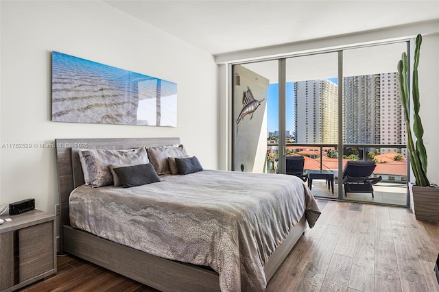 bedroom featuring expansive windows, a view of city, and wood-type flooring