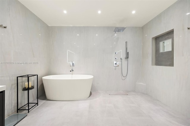 full bathroom with a shower, a soaking tub, tile walls, and vanity