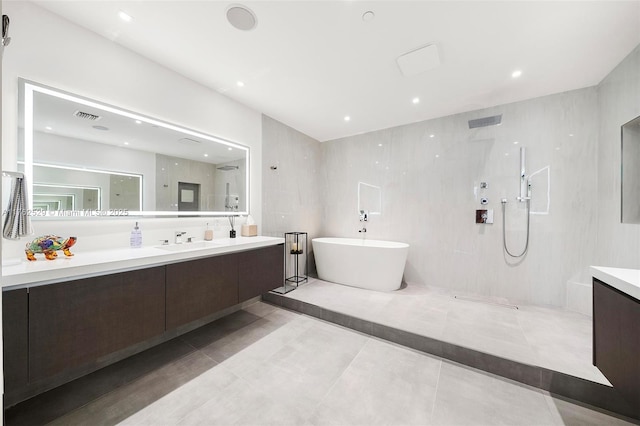 full bathroom featuring a freestanding tub, visible vents, vanity, and a walk in shower