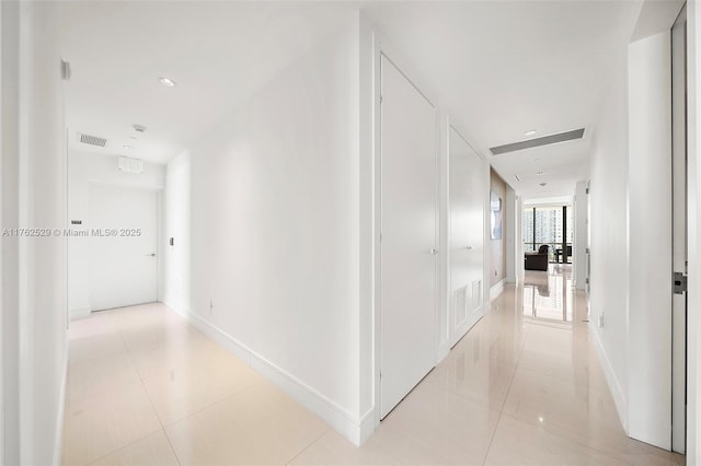 hallway with recessed lighting, light tile patterned flooring, baseboards, and visible vents