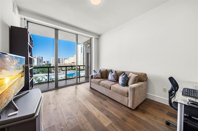 living room featuring hardwood / wood-style flooring, floor to ceiling windows, visible vents, and baseboards